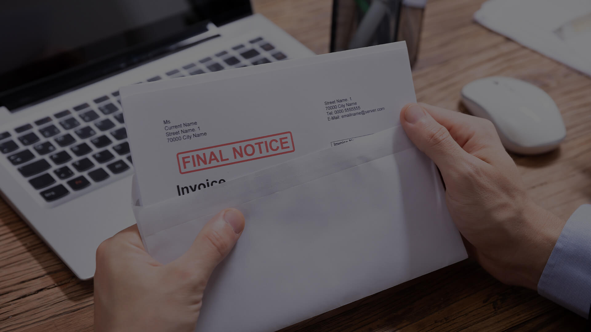 Close up of a person holding an open envelope with a paper sticking out that has the words "Final Notice."