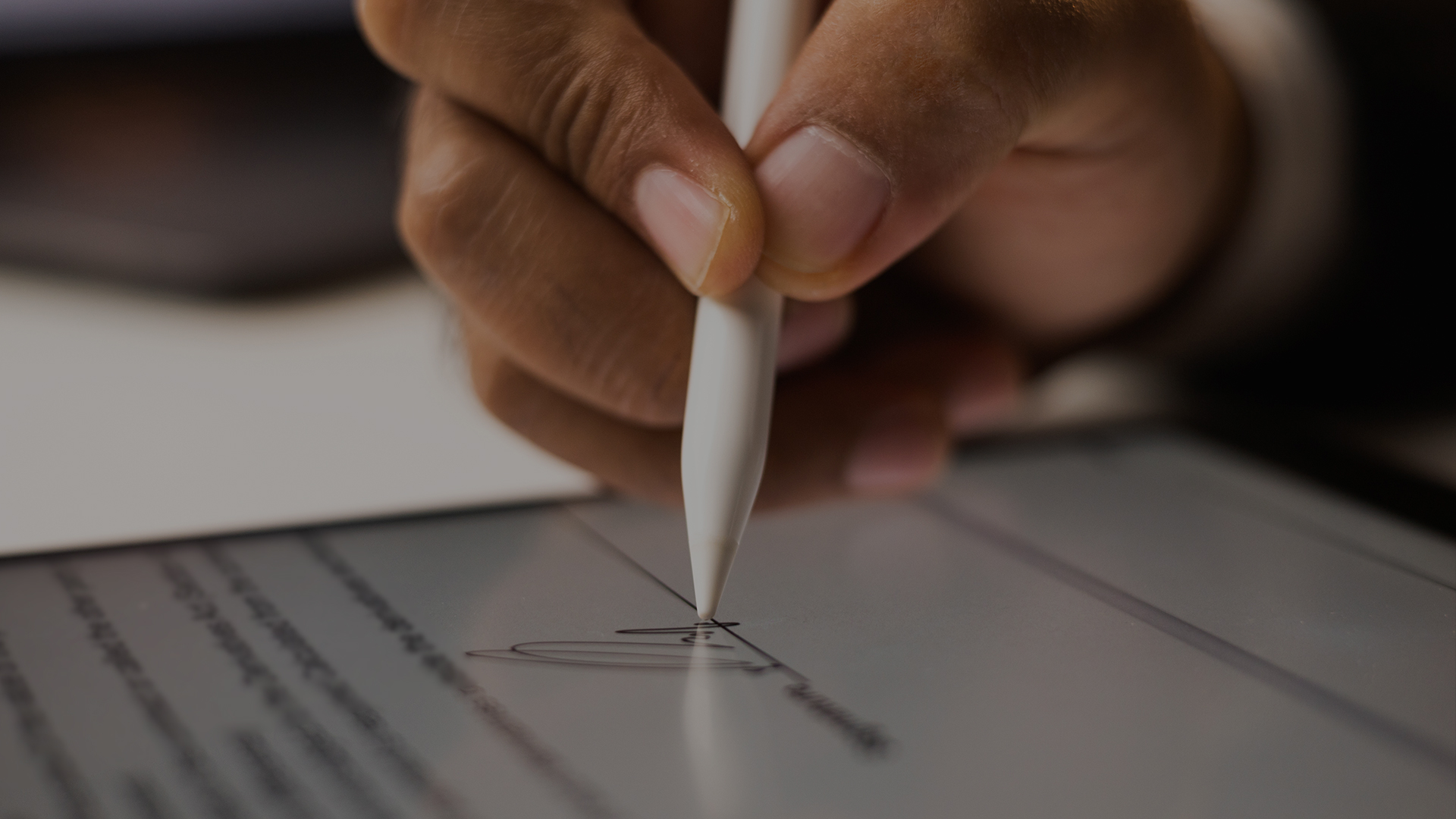 Close up of person signing a document on a tablet